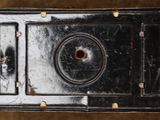 an old camera with a hole in the middle of it