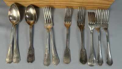 cinq fourchettes et cinq cuillères sur un support en bois