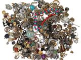 a pile of assorted jewelry on a white surface