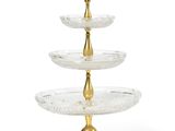 a three tiered glass cake stand with gold accents