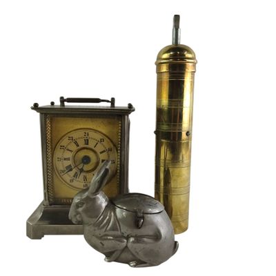 a small elephant statue next to a clock and a lighter