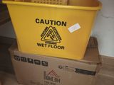 a yellow bucket sitting on top of a box on the floor