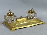 a gold desk set with two glass bottles on top of it