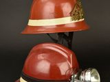 a red fireman ' s helmet with a light on it