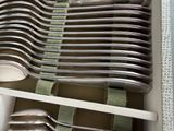 many spoons and forks in a drawer on a shelf