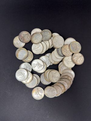 pile of silver coins on a black surface