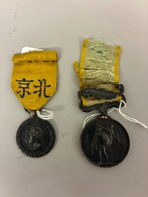 deux médailles portant des inscriptions en chinois, placées l'une à côté de l'autre