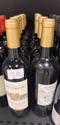 several bottles of wine are lined up on a shelf in a store