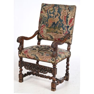 an old chair with a tapestry upholstered on the back