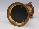 a gold clock with a black face on a white background