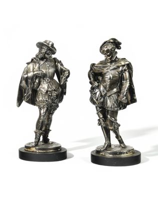 three bronze figurines of men dressed in costumes and hats