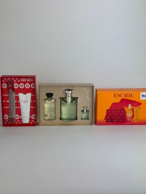 four different types of perfumes are lined up on a shelf