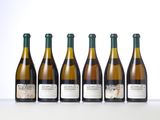six bottles of wine lined up in a row on a table