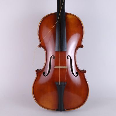 an old violin sitting upright on a white surface