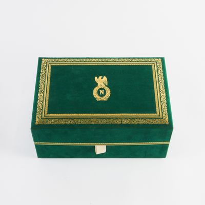 an image of a green box with gold trimming and a gold letter s on it