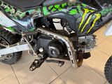 a green and black dirt bike on display in a showroom