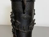 a black vase with a handle on a table