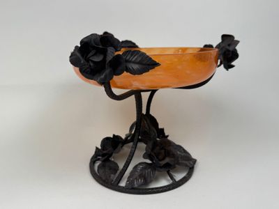 un petit bol orné de fleurs, posé sur un socle