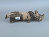une photo d'une figurine représentant un cochon, sur laquelle est accrochée une étiquette