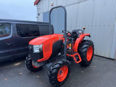 une photo d'un tracteur rouge garé devant un bâtiment