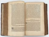 an open book on a white surface with a black border