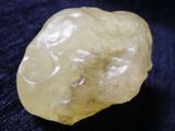 a close up of a yellow diamond on a blue cloth