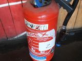 a fire extinguisor sitting on the floor next to a wall