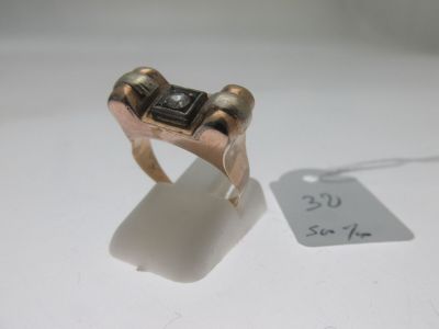 une bague ornée d'une pierre noire et à laquelle est attachée une étiquette de prix