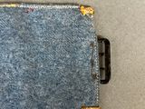a small piece of denim on the floor next to a cell phone