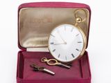 a gold pocket watch and a pair of scissors in a red case