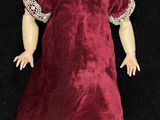 a doll that is wearing a red dress and white socks