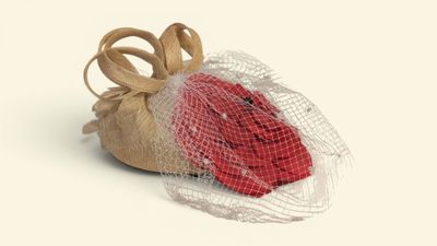 a bag with a red rose inside of it on a white surface