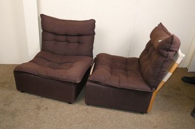 une paire de chaises marron dans une pièce avec de la moquette et des murs blancs