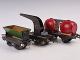 un petit train miniature sur lequel est posé un char rouge