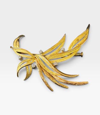 une image représentant une broche en forme d'oiseau en or et diamants