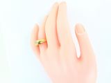 a woman ' s hand with a gold ring on it