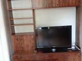 a picture of a living room with a tv and entertainment center