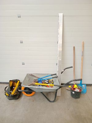 une brouette chargée d'outils devant la porte d'un garage