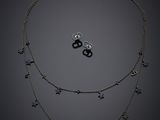 un gros plan d'un collier et de boucles d'oreilles sur fond noir