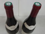 two bottles of wine sitting on top of a counter next to each other
