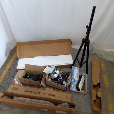une boîte contenant du matériel électronique posée par terre à côté d'un trépied