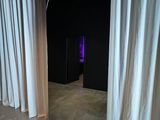 a large mirror in the middle of a room with white curtains