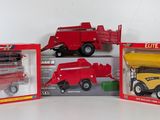 three red and yellow toy trucks in boxes on a white surface