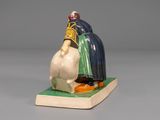 a figurine of a man sitting on top of a book