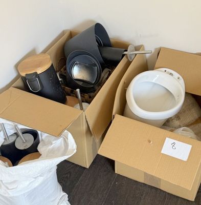 a box with a toilet in it next to a pile of boxes