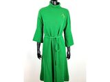robe en maille verte avec une étoile dorée sur le col et les poignets