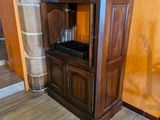 une armoire en bois surmontée d'un casier à bouteilles