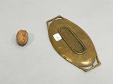 a nut and a brass plate on a white surface