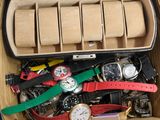 une boîte remplie de montres et des montres posées sur une table