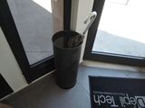 a black trash can with a pair of scissors in it